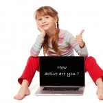 Little girl sitting on floor showing laptop screen